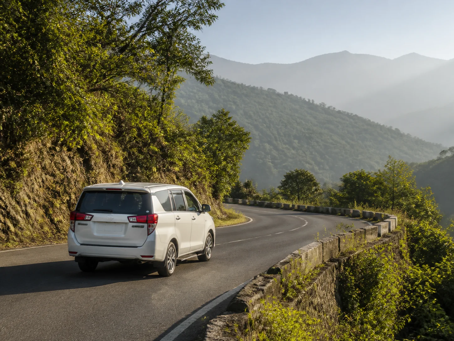 A private passenger vehicle following a quiet mountain road