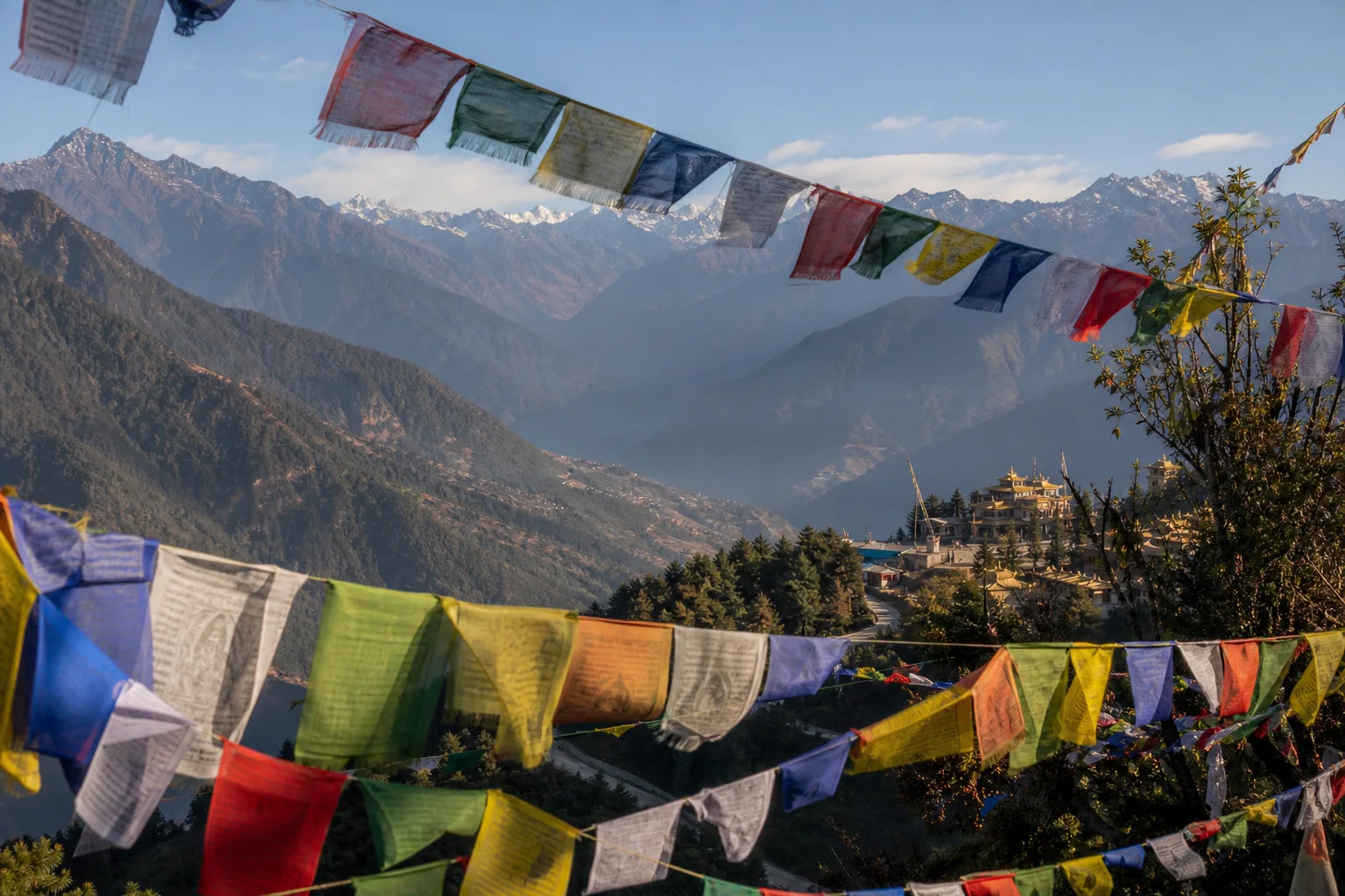 Prayer flags looking across the layered hills of Sikkim